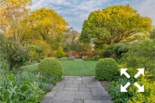 View of Bates Green Garden - a symmetrically designed country cottage garden with mixed borders flowering in Spring - April